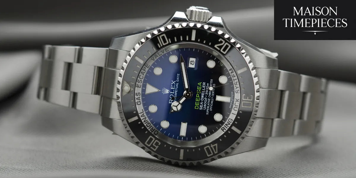 Close-up of a Rolex Deepsea Sea-Dweller men’s luxury watch on a satin grey surface, showcasing the detailed dial and bezel.
