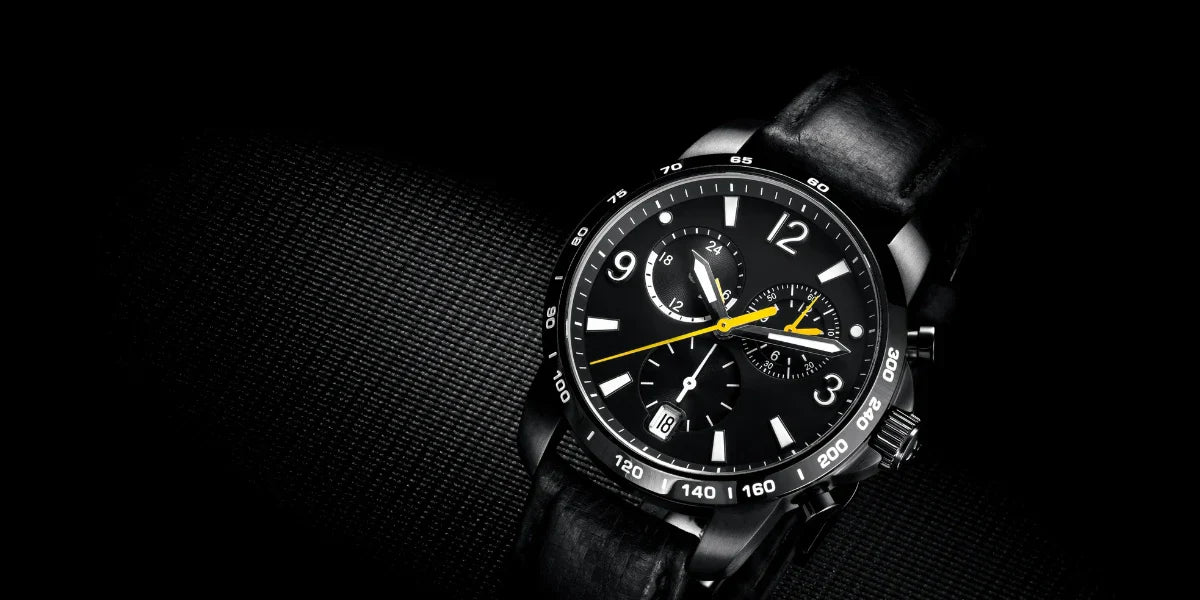 Black chronograph men’s watch with leather strap on dark textured background