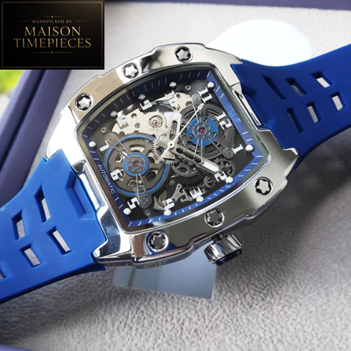 Maison Timepieces Curated automatic skeleton sports watch with 43mm black tonneau case, visible mechanical movement, orange silicone strap, luminous hands and transparent exhibition caseback.