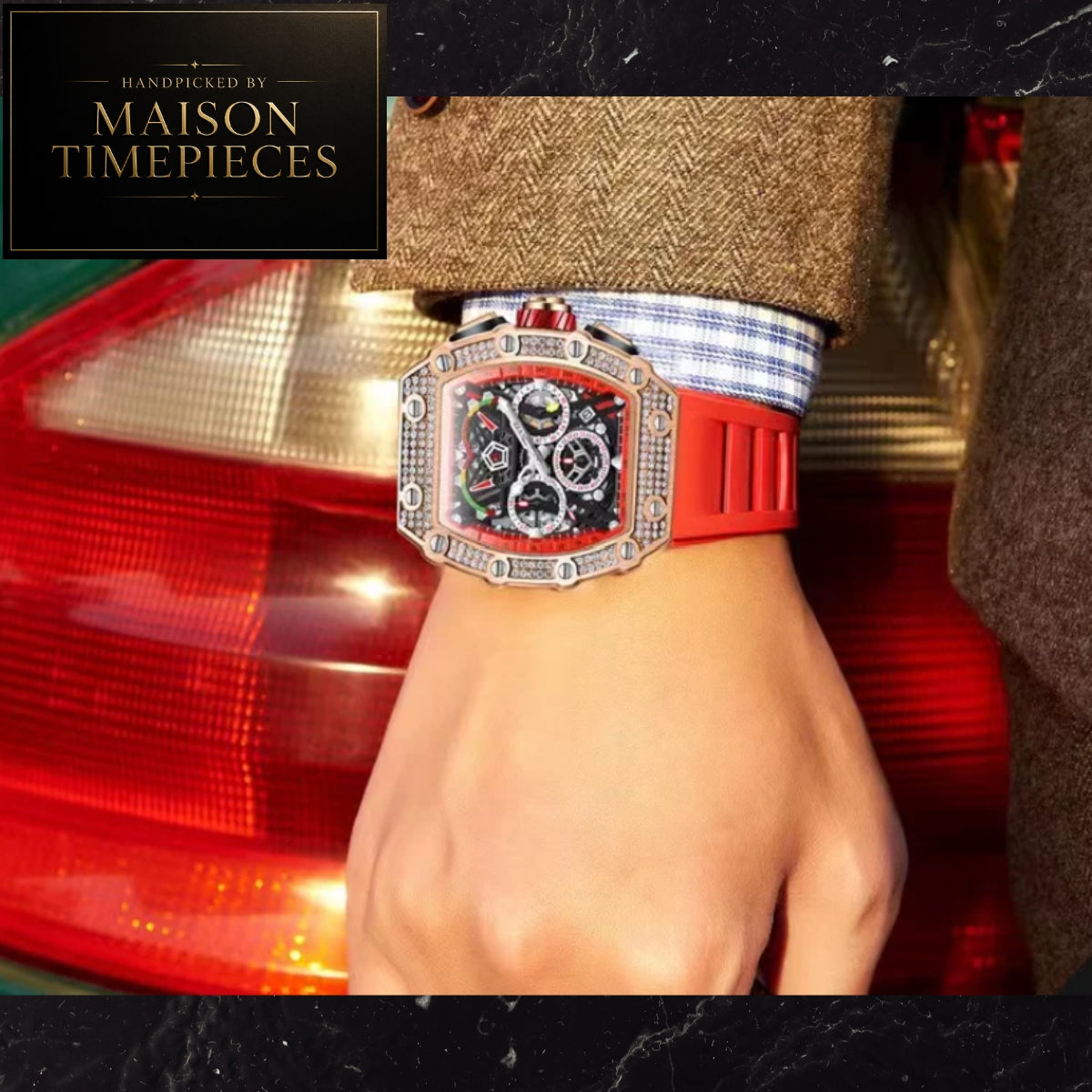 A close-up of a wrist wearing a Maison Timepieces watch with a silver-tone rectangular case, black dial, and bright red strap, shown against a blurred red car background. A Maison Timepieces branded overlay appears in the top-left corner.