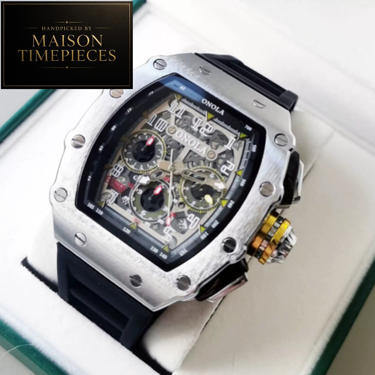A luxury skeleton watch by Onola, displayed inside a white watch box. The watch features a silver-toned titanium case, a black rubber strap, and a detailed skeleton dial showing the inner gears.