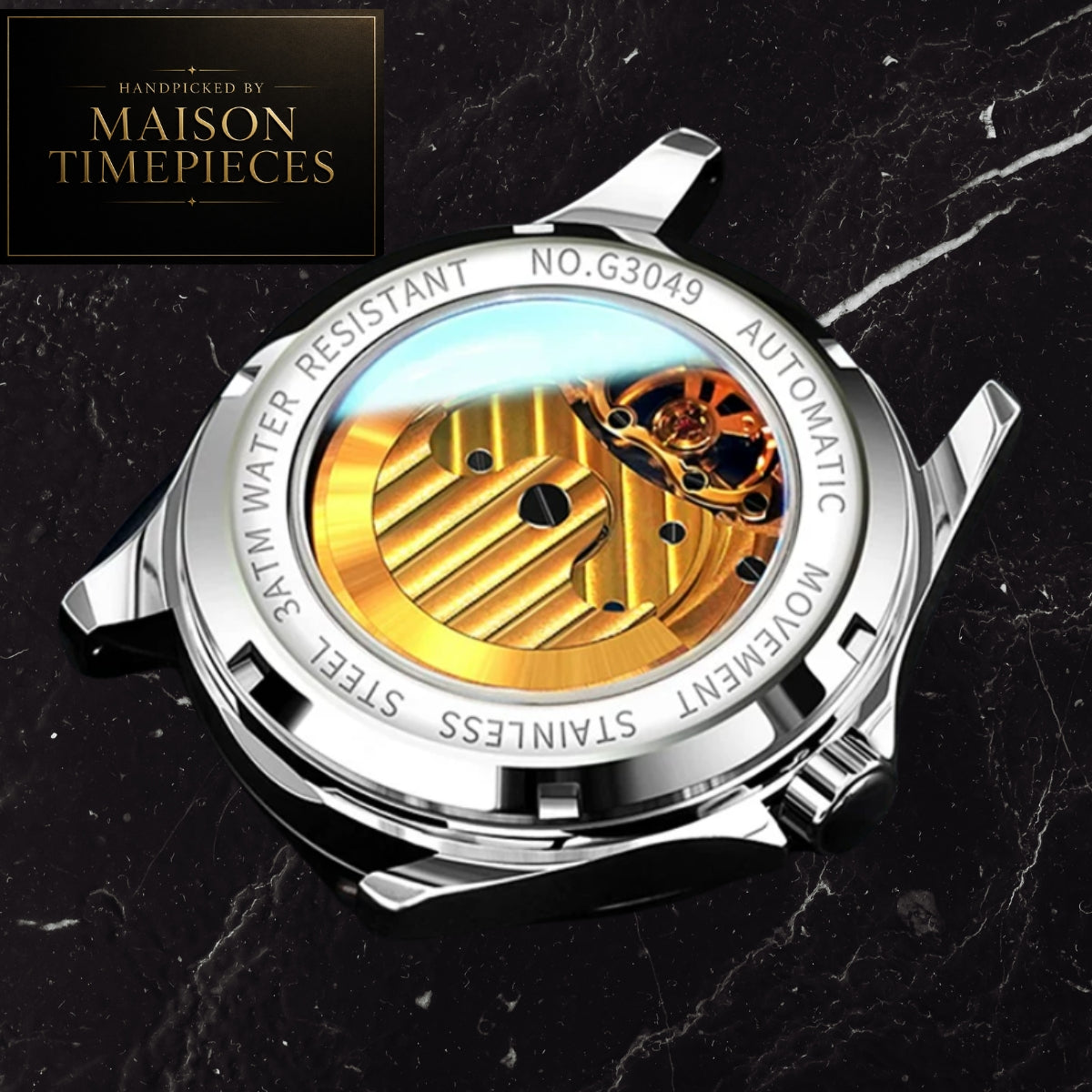 Close-up of the back case of a stainless steel watch with a transparent water-resistant case, showing a gold-toned automatic movement and internal components. The watch is photographed on a dark marble surface, with a Maison Timepieces logo in the top-left corner.