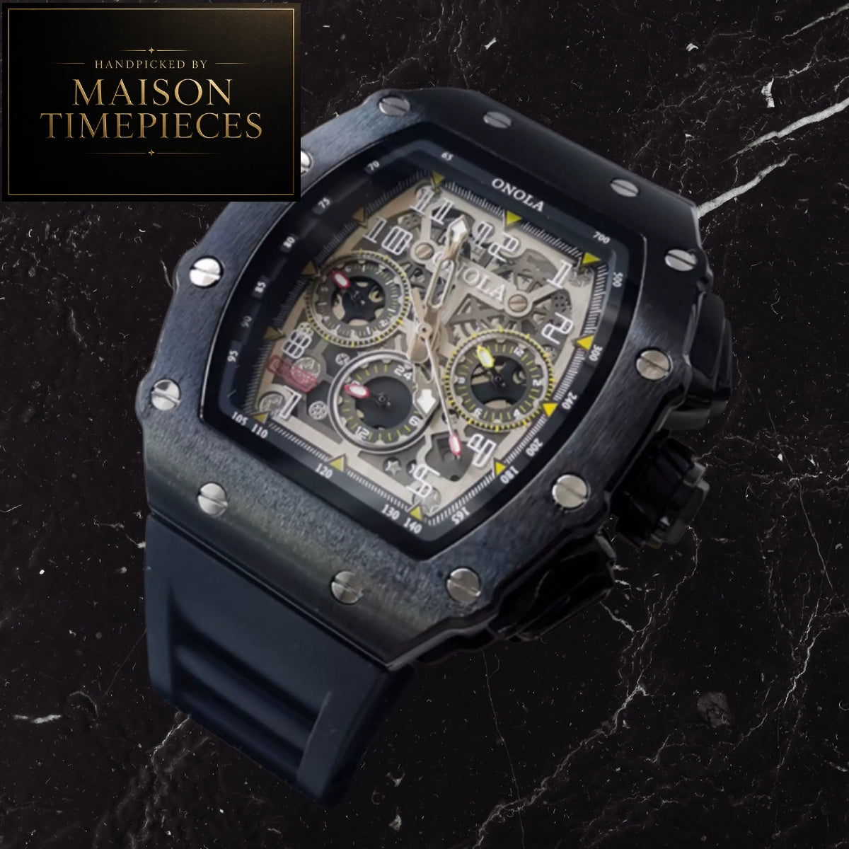 A Maison Timepieces handpicked Onola watch with a black carbon fiber case, skeleton dial showing beige and gold inner gears, and a dark blue rubber strap, set against a black marble background.