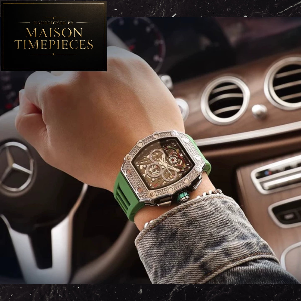 A close-up of a wrist wearing a Maison Timepieces luxury watch with a green strap and a silver-tone case encrusted with clear stones, set against a background of a car interior with a Mercedes-Benz logo.