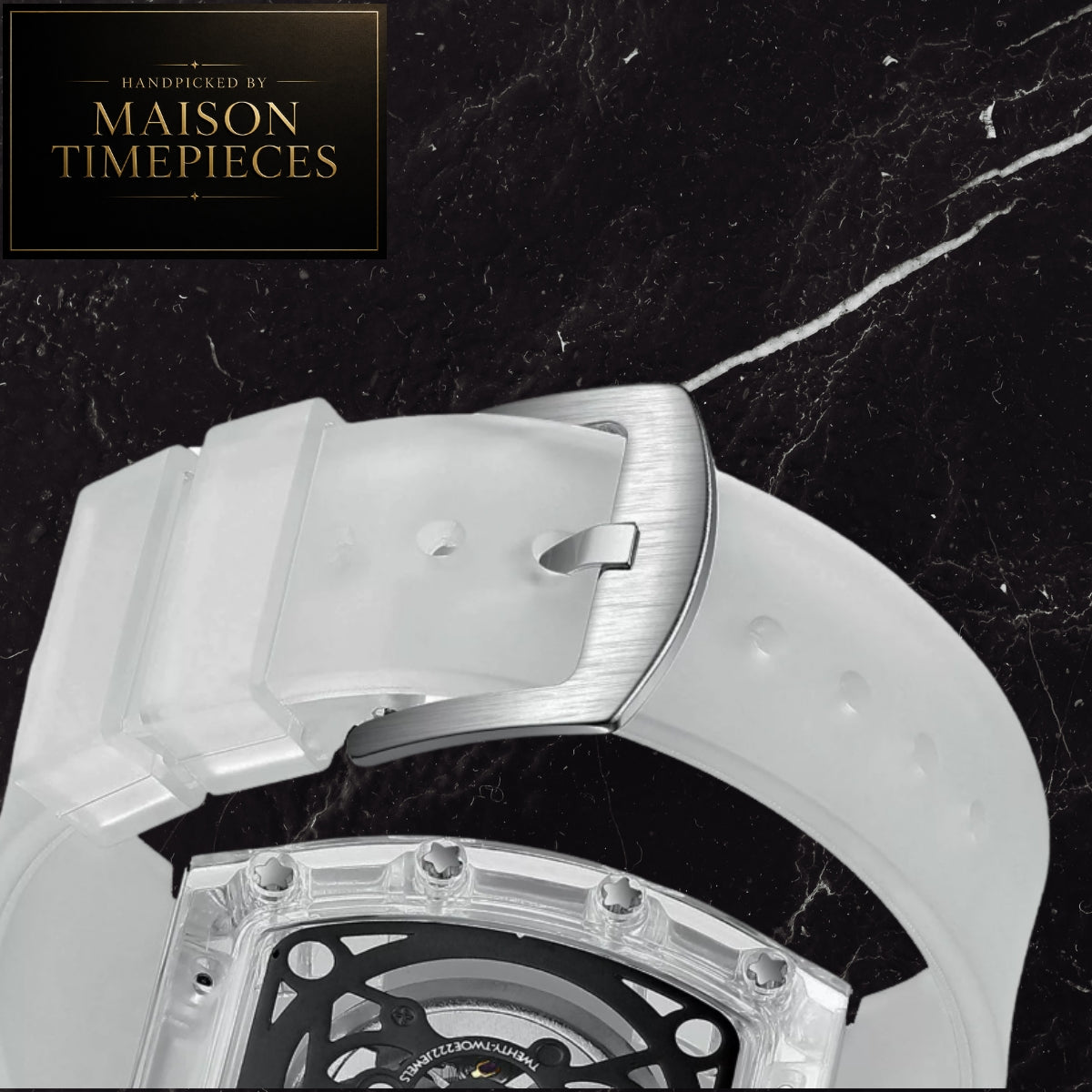 Close-up of a Maison Timepieces watch showing a translucent white silicone strap and a brushed silver metal buckle, set against a black marble background with a Maison Timepieces logo in the top-left corner.