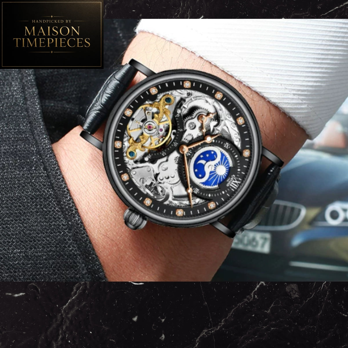A skeleton watch with a black leather strap and a detailed open-heart dial showing gold and blue mechanical components, worn on a wrist. A black brand card for Maison Timepieces is visible in the top-left corner.