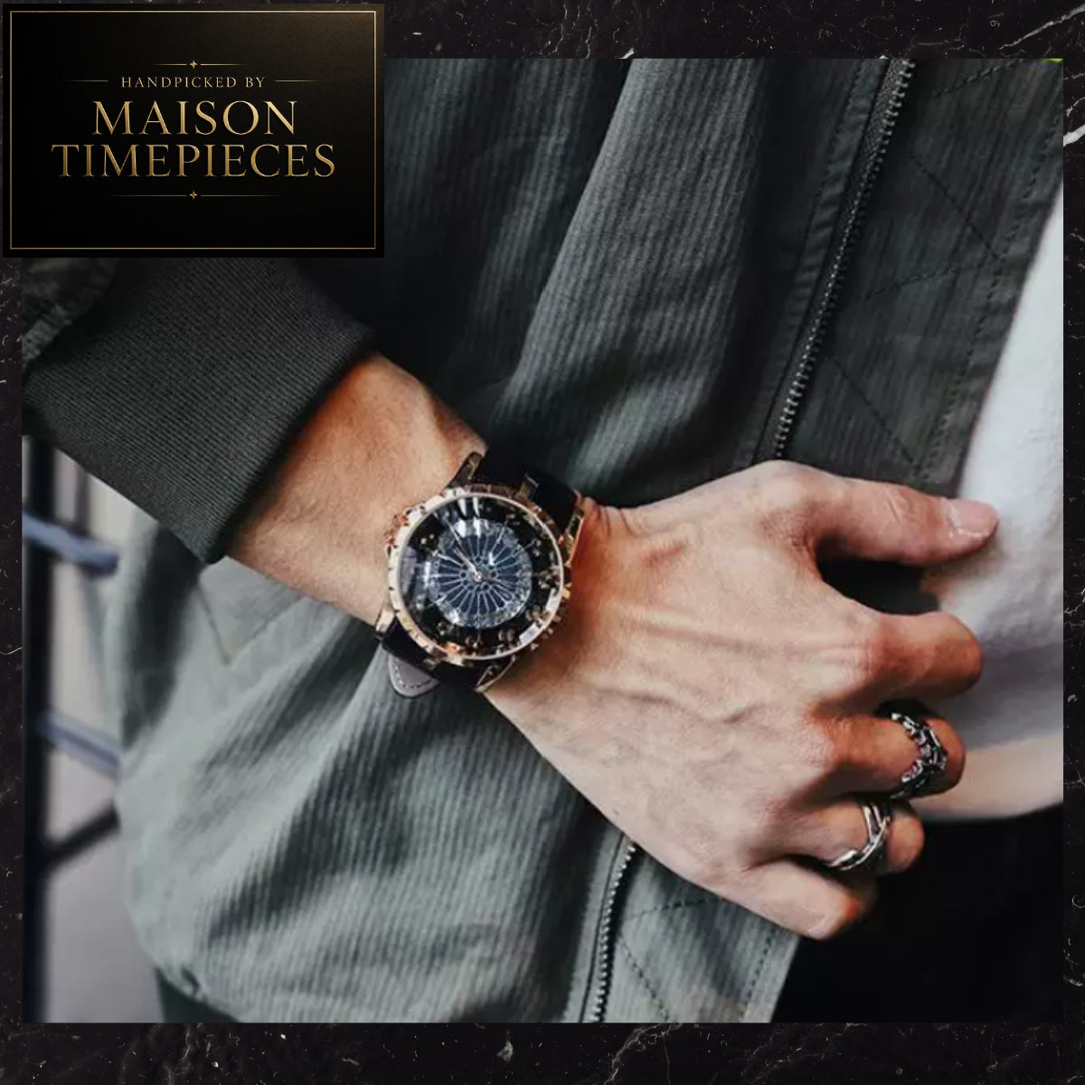 A close-up lifestyle shot of a man's wrist wearing a Maison Timepieces watch. The watch features a round black dial with a blue sunburst pattern, a rose gold bezel, and a black leather strap.