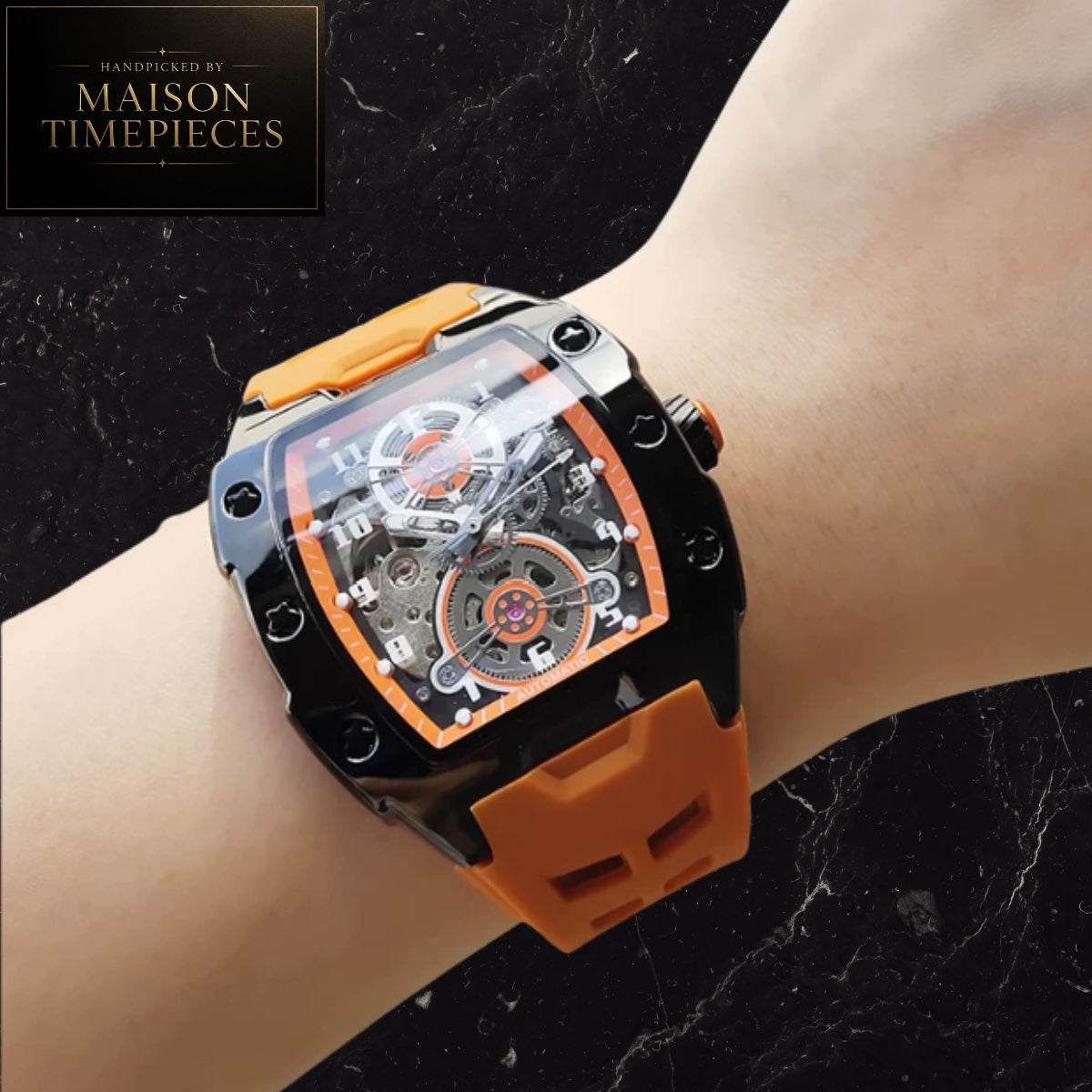 Maison Timepieces Curated automatic skeleton sports watch with 43mm black tonneau case, visible mechanical movement, orange silicone strap, luminous hands and transparent exhibition caseback.