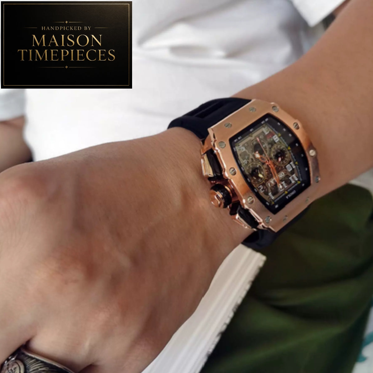 A close-up of a wrist wearing a Maison Timepieces watch with a rose gold case, black strap, and transparent dial showing a mechanical movement. A Maison Timepieces logo overlay is in the top-left corner.