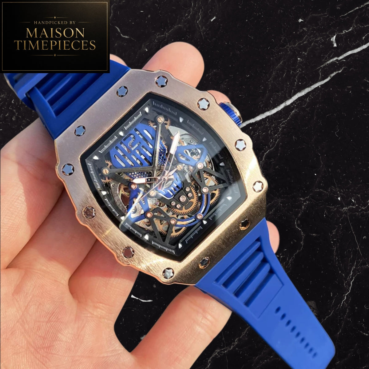 Maison Timepieces Curated automatic skeleton tonneau watch with rose gold alloy case, blue skeleton dial, automatic mechanical movement, exhibition caseback and blue silicone strap.