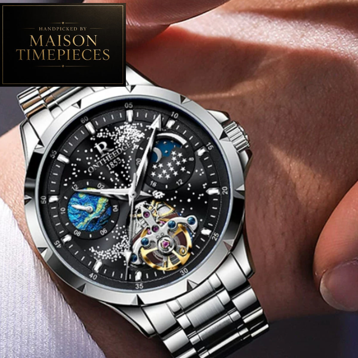 A close-up of a silver stainless steel wristwatch with a black dial featuring a moonphase and earthwatch design, worn on a person's wrist. A black brand overlay in the top left corner reads 'PROMOVED BY MAISON TIMEPIECES'.