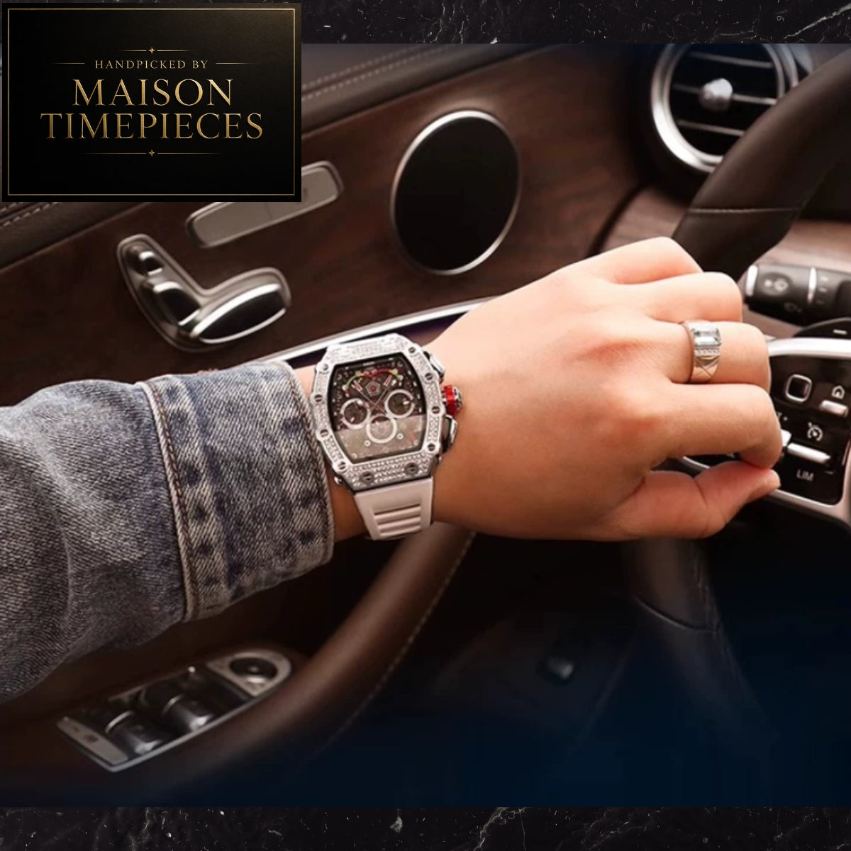 A silver-toned Maison Timepieces watch with a white strap and multi-dial face is worn on a person's wrist inside a luxury car with brown leather interior. A brand overlay in the top-left corner reads 'Handcrafted by Maison Timepieces'.
