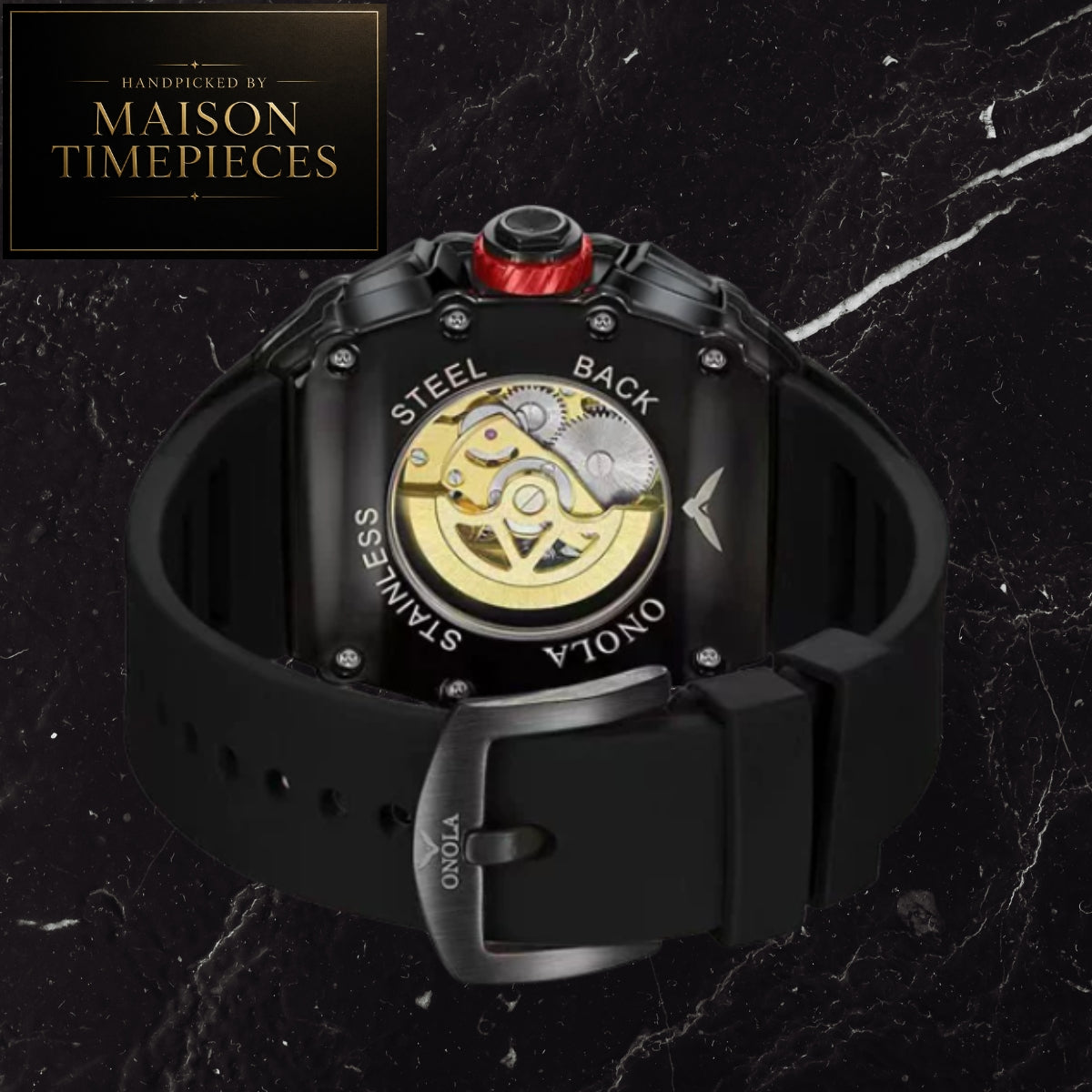 A close-up of a Maison Timepieces automatic watch showing the back case with a transparent dial revealing gold-toned gears, a black rubber strap, and a red crown accent, set against a dark marble background with a Maison Timepieces badge in the top-left corner.