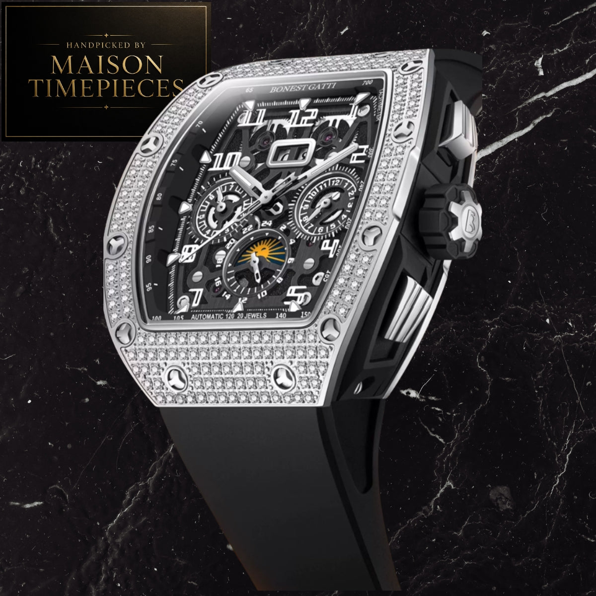 A Richard Mille-style chronograph wristwatch with a black dial, silver-toned case, diamond-like bezel, and black strap, shown on a dark marble background with a Maison Timepieces badge in the top-left corner.