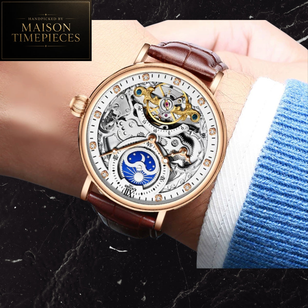 A close-up of a skeleton watch with a brown leather strap and rose gold case, worn on a wrist. The watch face is open, showing intricate gold and silver mechanical gears, a blue moon phase dial, and crystal hour markers.