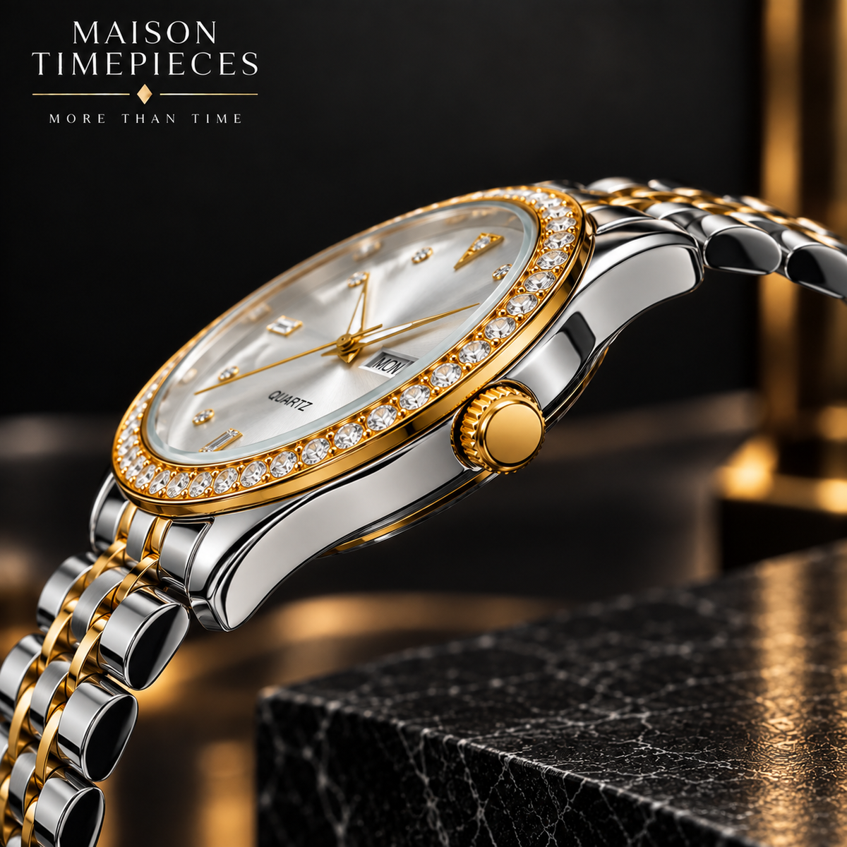 A Maison Timepieces men's watch with a two-tone silver and gold stainless steel bracelet, a gold bezel set with pavé crystals, and a white dial with gold accents, shown on a dark marble block with a dark background.